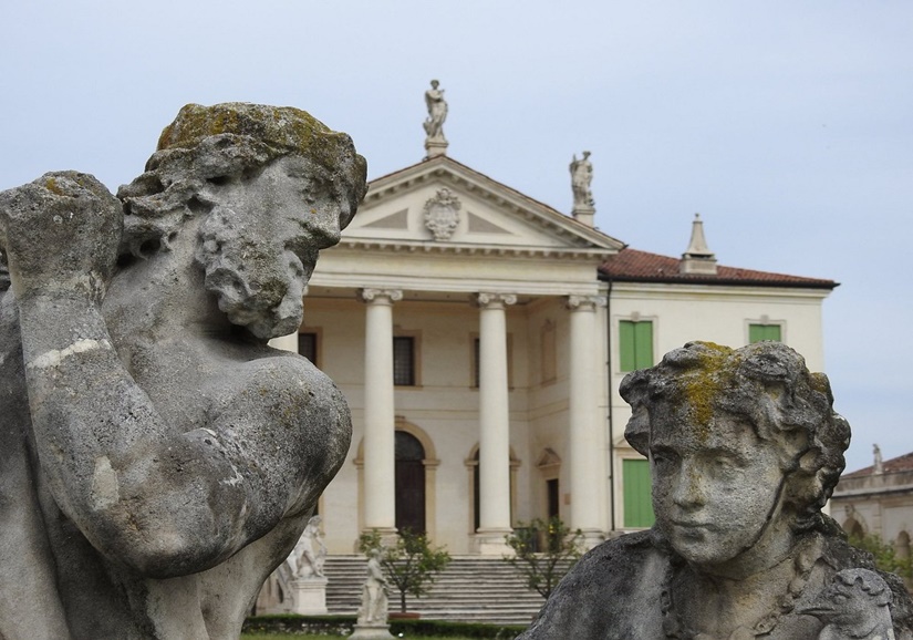 visita guiada Villa Cordellina Montecchio Maggiore: estatuas verdes en primer plano con villa clásica al fondo.