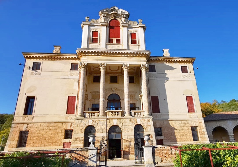 Visite guidate Villa Fracanzan: elegante facciata con colonne e finestre rosse in un contesto naturale.