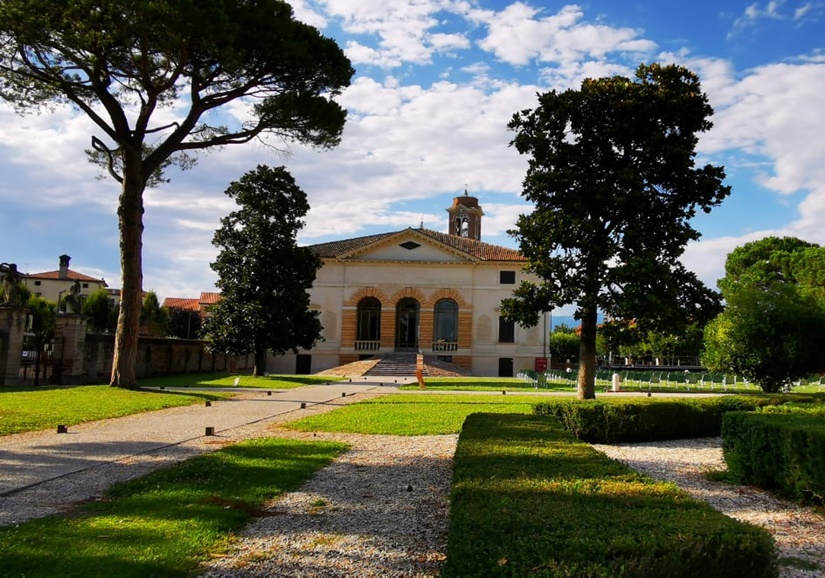Visitas guiadas Villa Caldogno: elegante jardín con árboles y una villa histórica al fondo.