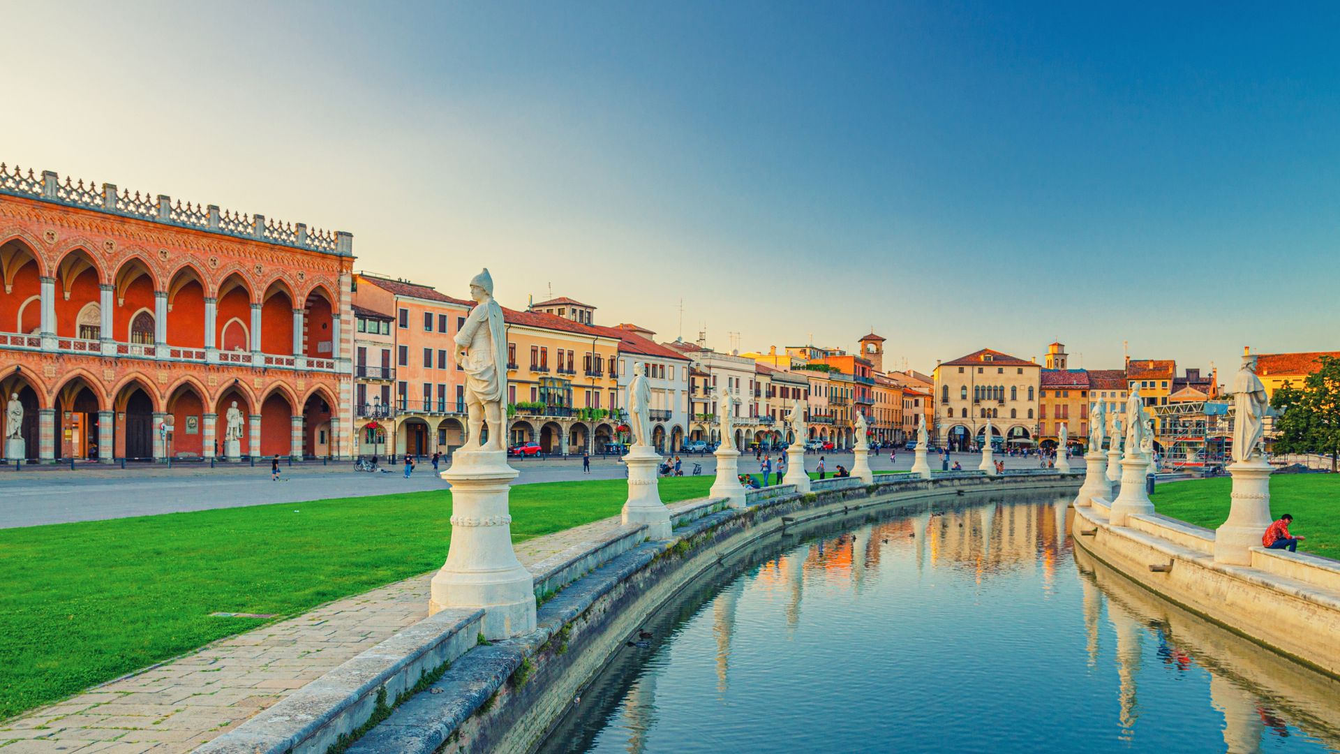 Visite guidate Padova, panorama con statue e riflesso nell'acqua in una piazza storica.