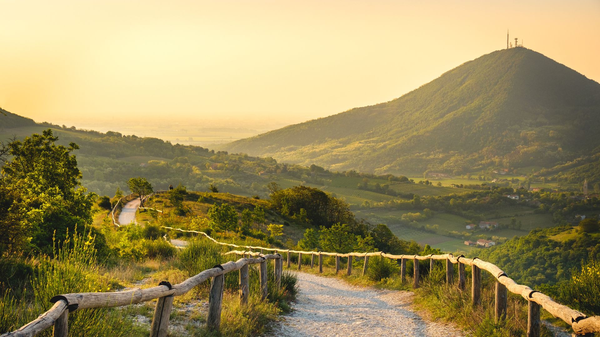 Visite guidate provincia di Padova, panorama montano al tramonto con sentieri e vegetazione verde.