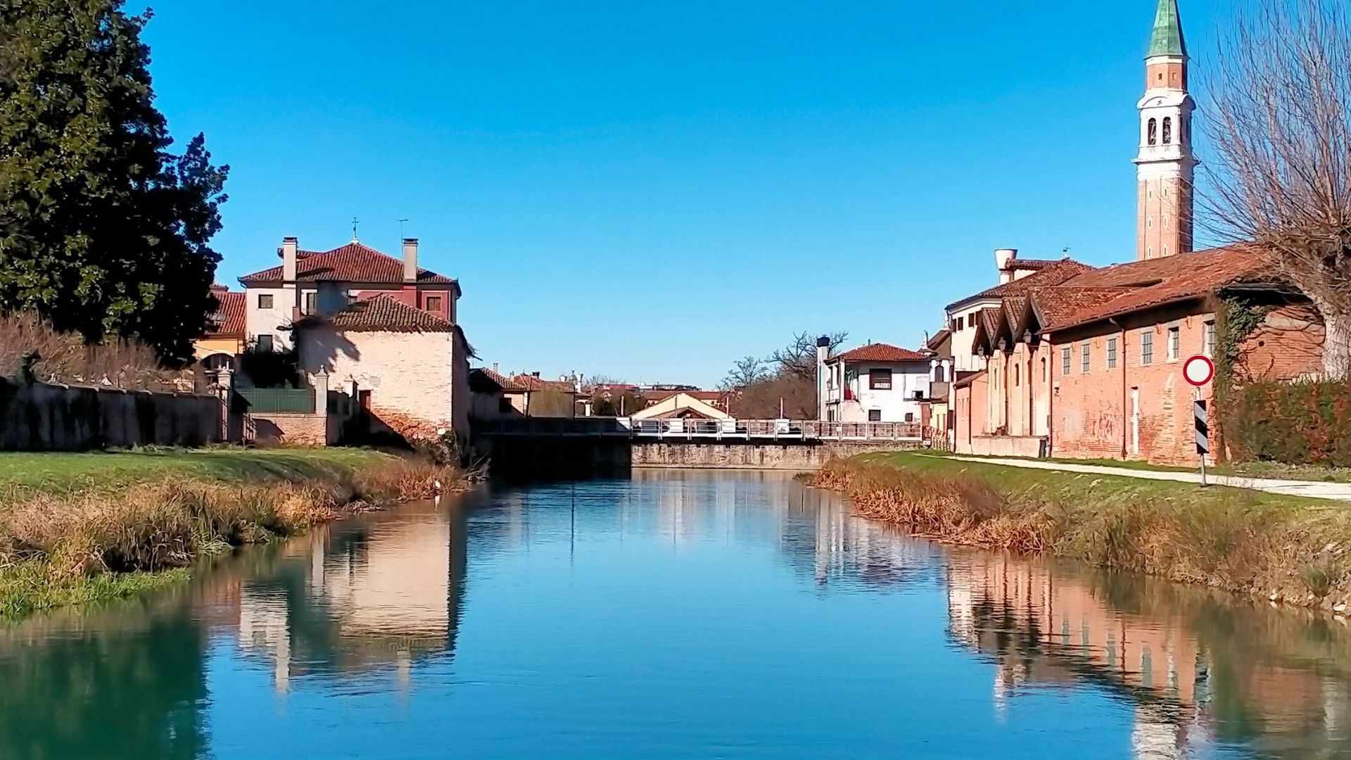 Visite guidate Riviera del Brenta, vista sul Naviglio con ville venete e vegetazione, riflessi nell'acqua.